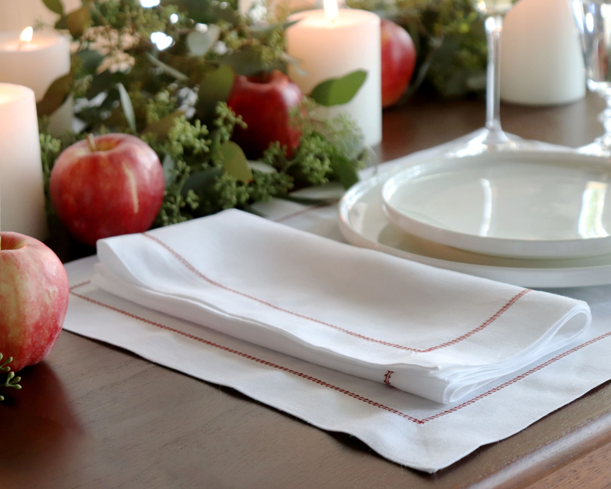 holiday entertaining white hemstitched linen napkin red trim Christmas placesetting